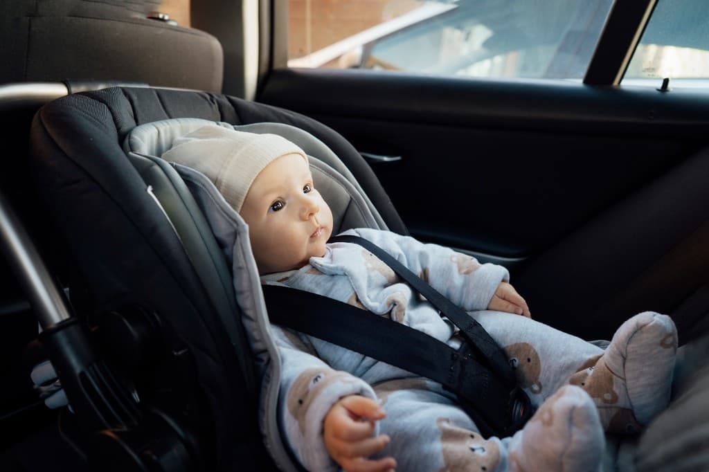A young child safely buckled into a car seat